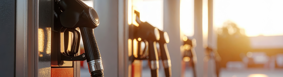 Fuel pump nozzle at gas station at dusk