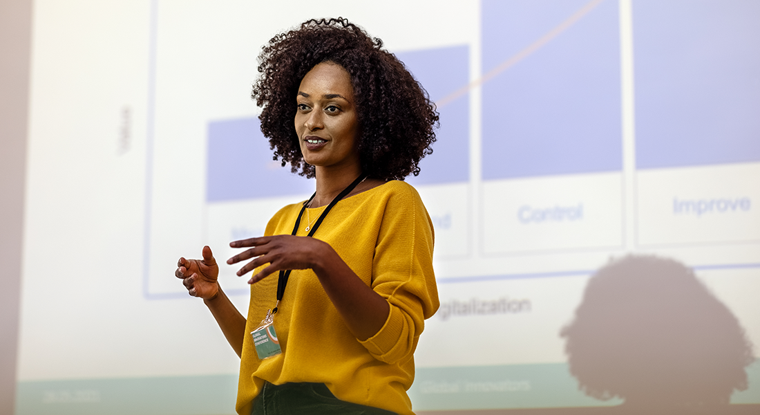 Woman presenting in front of chart screen