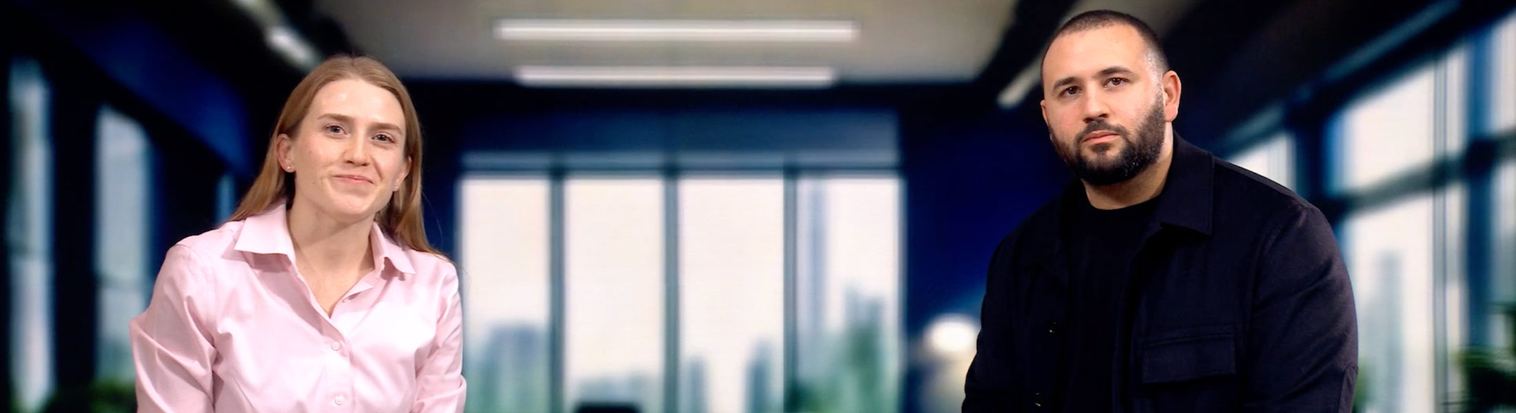 Two coworkers seated in a modern office lobby