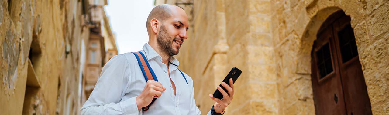 Man smiling while looking at phone