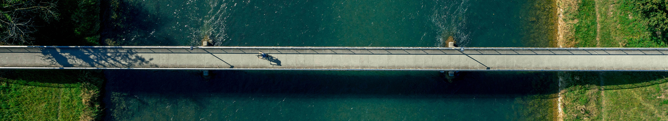 Osoba na kole přes most